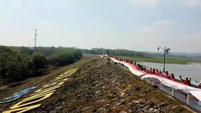 Para pegawai Disparbud Lamongan bersama warga membentangkan bendera merah putih di waduk Gondang Kecamatan Sugio Kabupaten Lamongan/Foto: Muhamat Sapii/Kanaltujuh.com