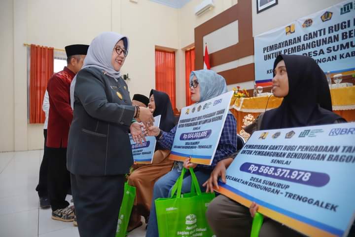 foto: Pjs Bupati Trenggalek Dyah Wahyu saat menyalurkan uang ganti rugi pada warga terdampak proyek pembangunan Dam Bagong