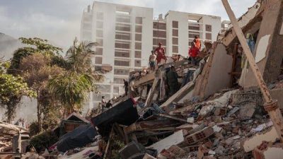 Tim penyelamat, warga sipil, dan petugas medis darurat mencari korban selamat di antara reruntuhan sejumlah bangunan yang ambruk di La Guaira, Venezuela,