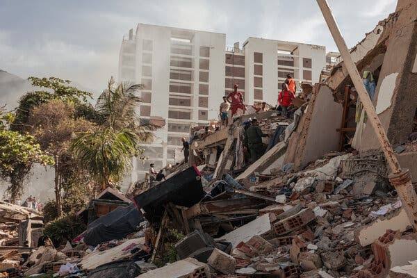 Tim penyelamat, warga sipil, dan petugas medis darurat mencari korban selamat di antara reruntuhan sejumlah bangunan yang ambruk di La Guaira, Venezuela,